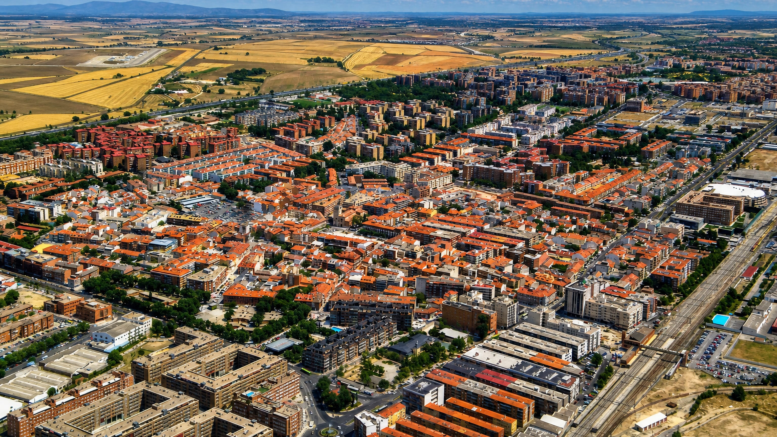 Torrejón de Ardoz, Spain, from the air: red-tiled apartment blocks and grid streets on the Madrid plain.