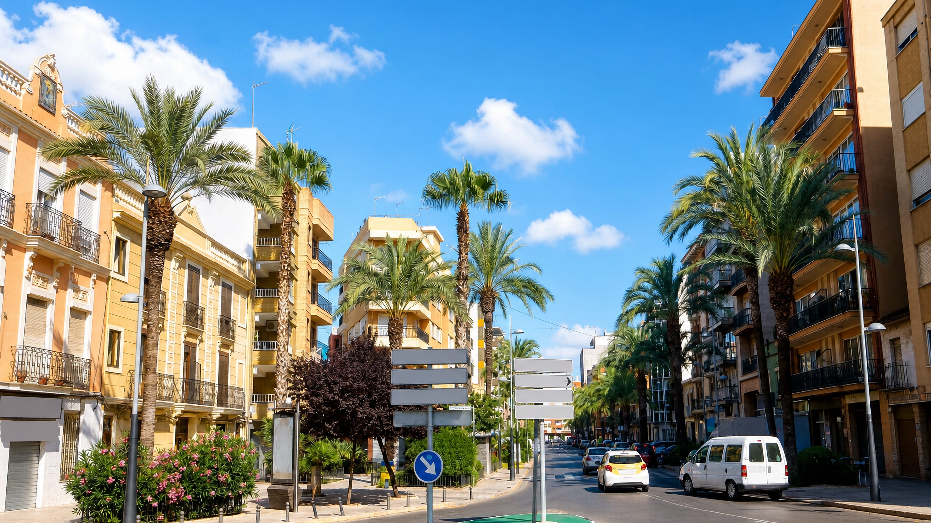 Palm-lined avenue of pastel apartment blocks under a blue sky in Torrent, Valencia