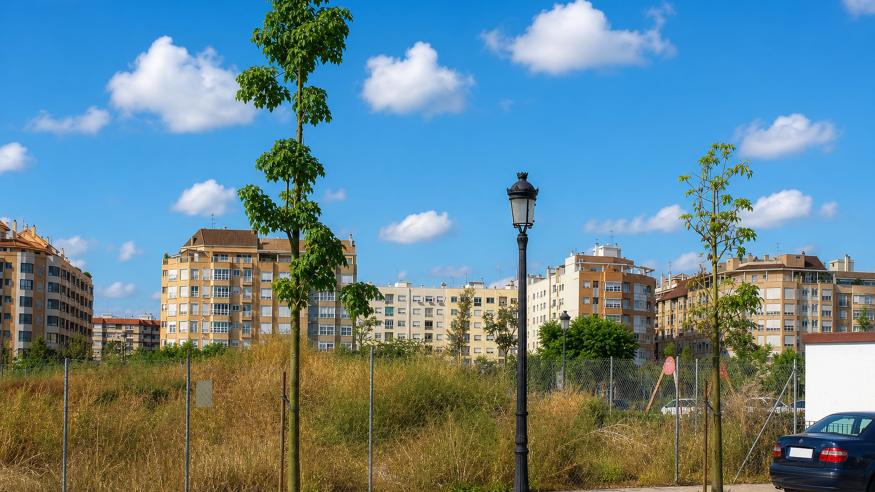 Apartment blocks behind a fenced patch of scrubland in Sant Isidre, a residential district of Valencia.