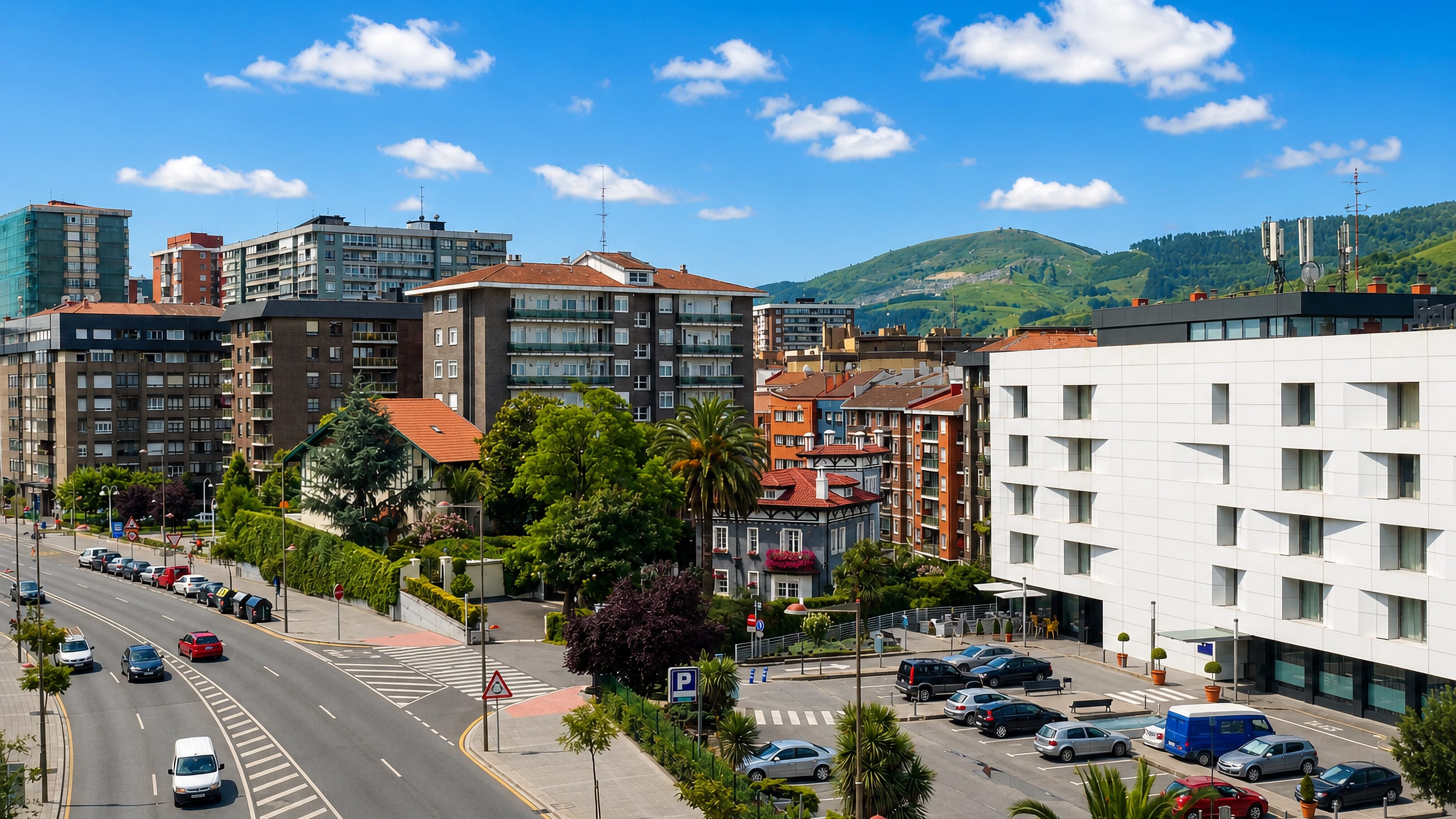 Apartment blocks and a broad avenue below green hills at Begoñalde, Bilbao.