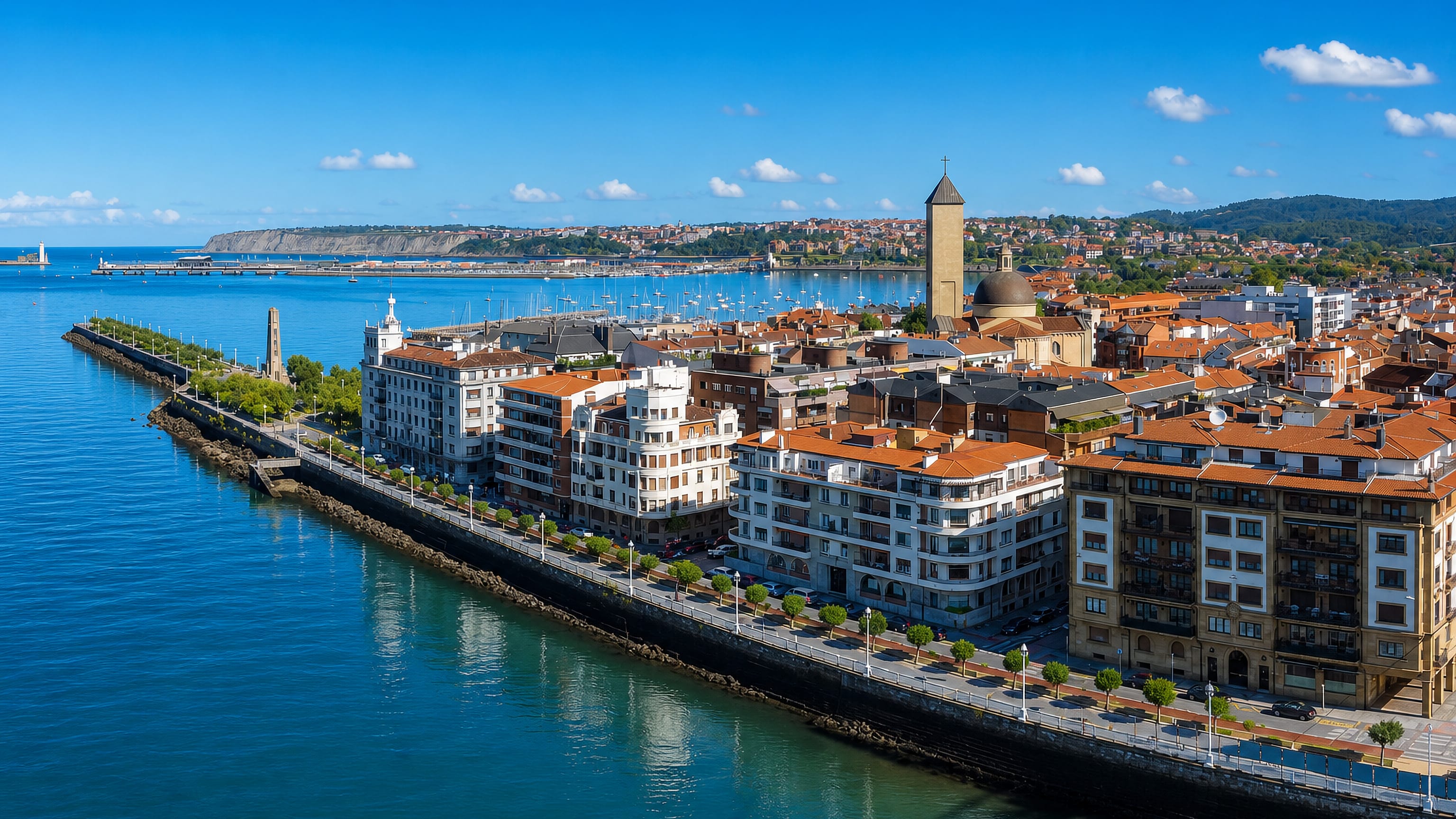 Aerial view of Getxo's seafront promenade, tiled roofs and domed church above the Abra bay in the Basque Country.