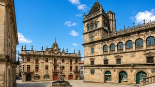 The granite Baroque buildings and fountain of a historic plaza in the old town of Santiago de Compostela, Galicia.