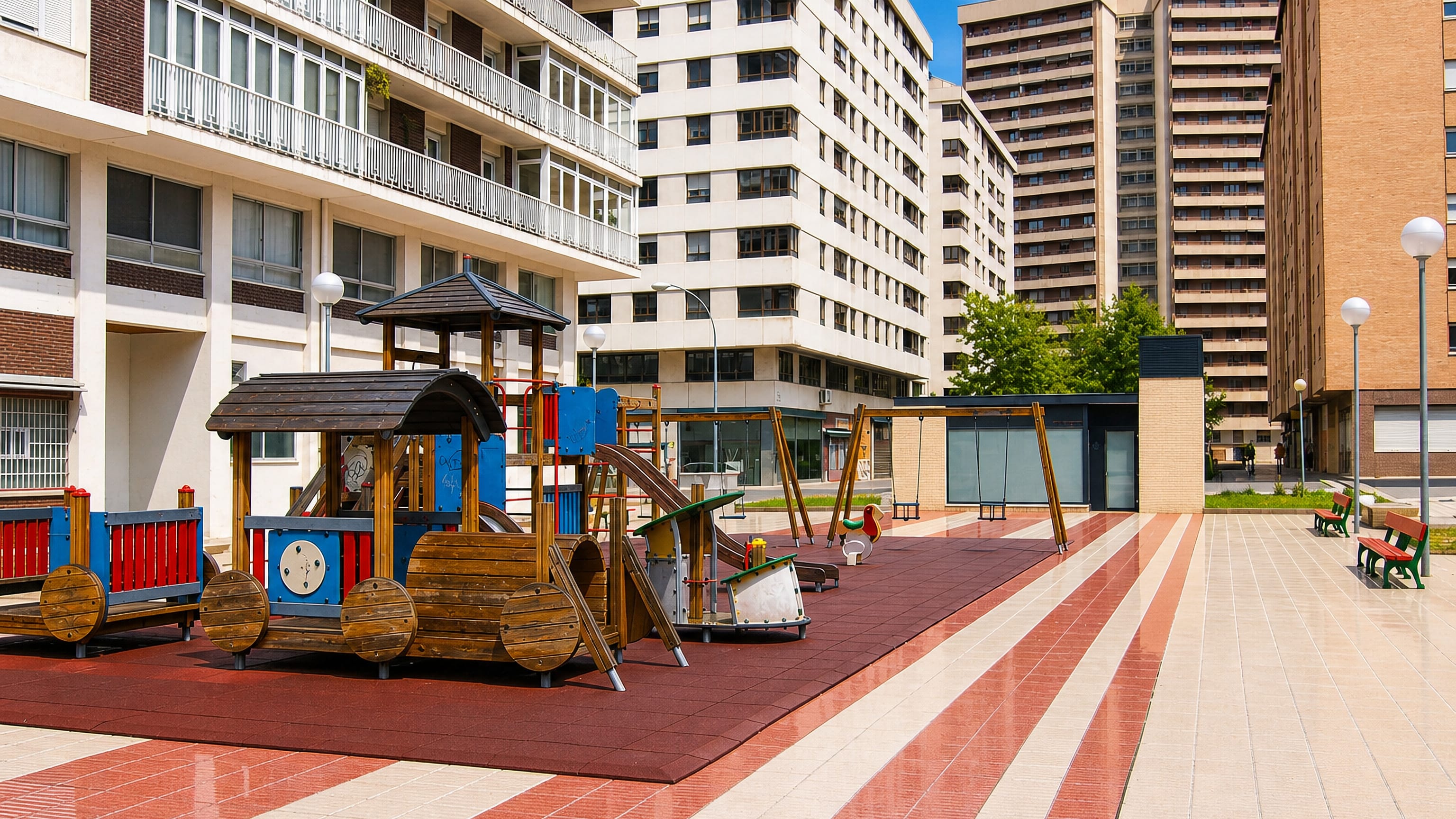 Playground and mid-century apartment blocks around a paved plaza in Iturrama, Pamplona.