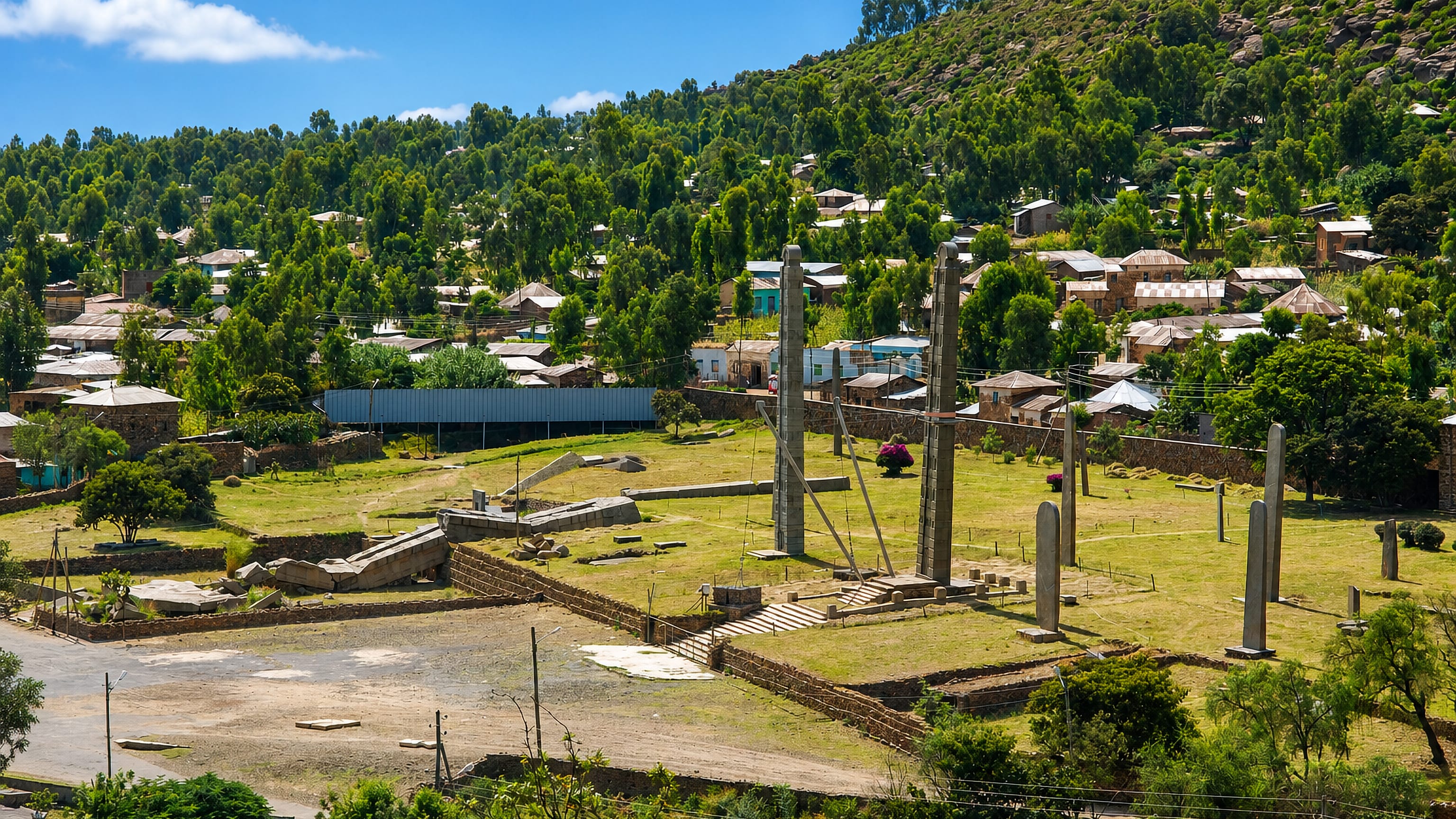 Aksum, Ethiopia, with its ancient granite stelae field below hillside homes and the wooded Tigray highlands.