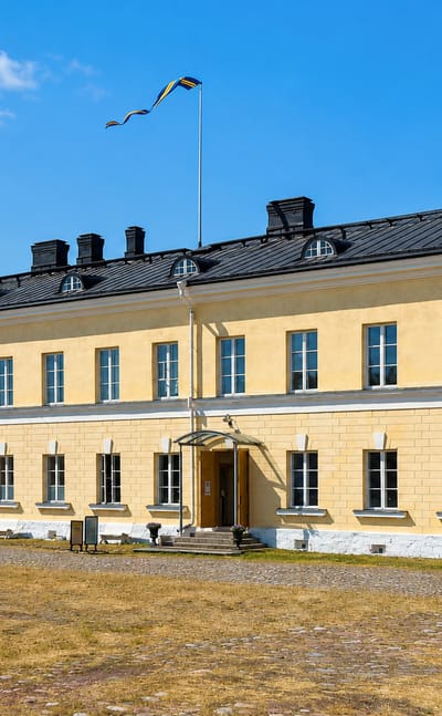 The yellow neoclassical Eckerö Post and Customs House under a blue sky, Åland, Finland.