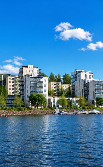 Modern waterfront apartment blocks and a small marina at Ainolanranta on the lakeshore in Jyväskylä, Finland.