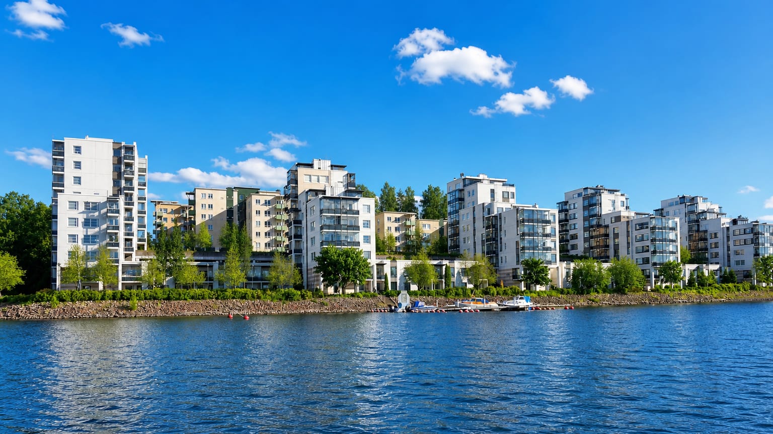 Modern waterfront apartment blocks and a small marina at Ainolanranta on the lakeshore in Jyväskylä, Finland.