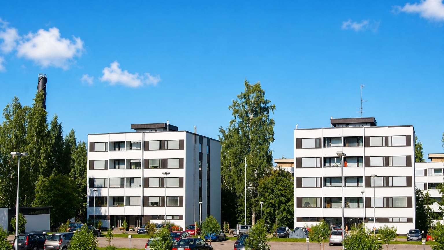 White apartment blocks and a car park among birches in Kortepohja, Jyvaskyla.