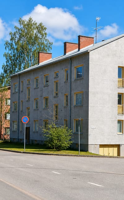 A 1950s plastered apartment block on a street corner among birches in Kukkumäki, Jyväskylä.
