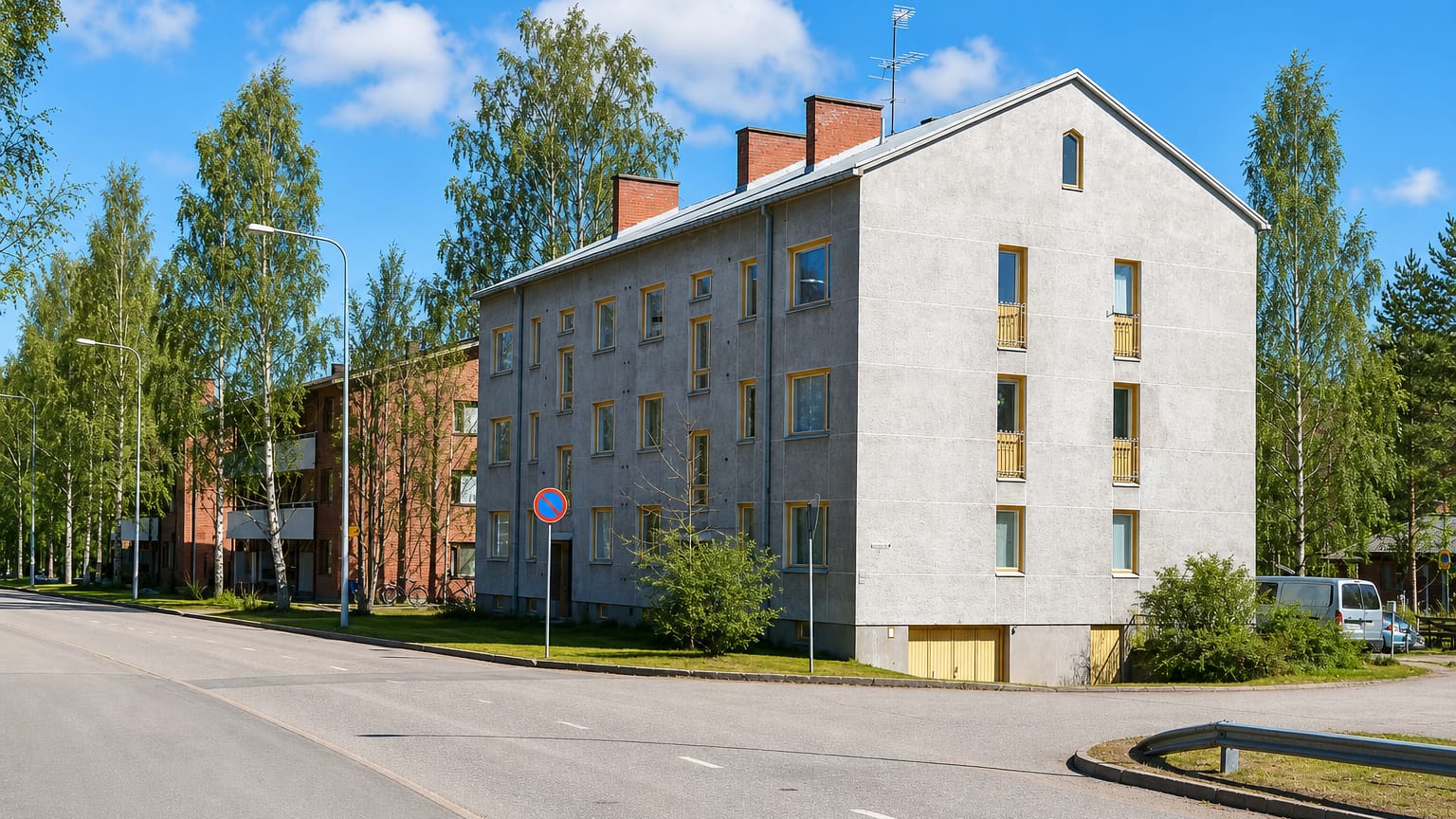 A 1950s plastered apartment block on a street corner among birches in Kukkumäki, Jyväskylä.