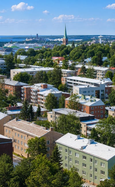 Aerial daytime view of Jyväskylä's Mäki-Matti district, Finland: apartment blocks, leafy streets and a lake on the horizon