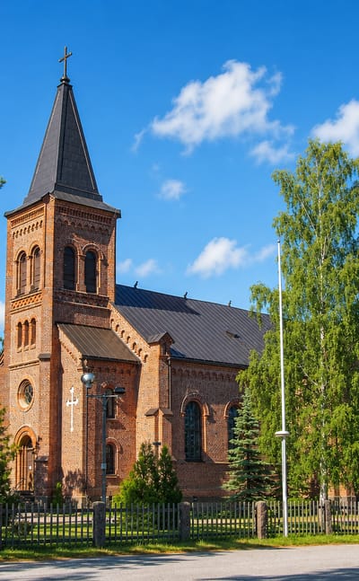 Red-brick neo-Gothic parish church with a tall steeple in Miehikkälä, Kymenlaakso, Finland.