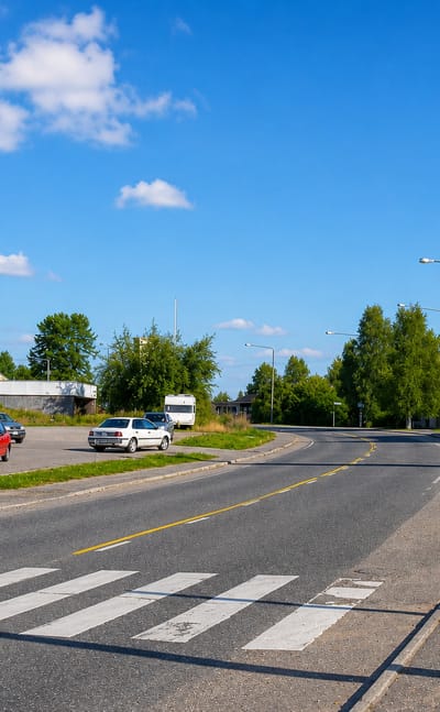 A quiet village street in Pelkosenniemi, Finland, with a small grocery store and roadside petrol station.