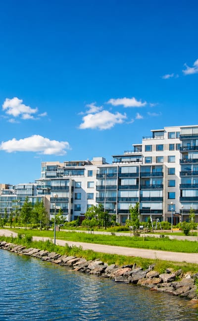 Modern lakeside apartment buildings along the Vesijärvi waterfront in Niemi, Lahti, Finland, under a clear blue sky