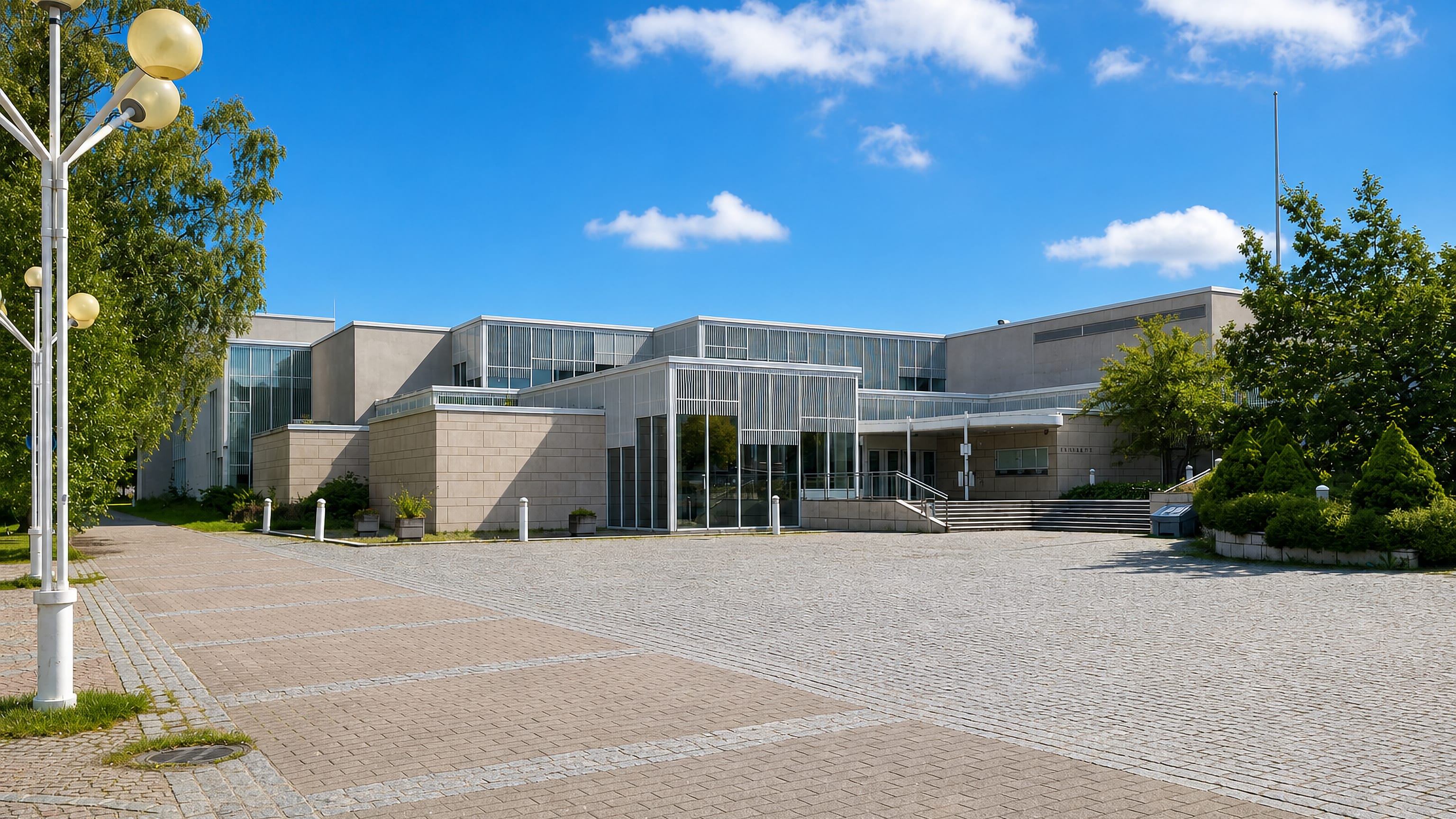 Modern campus building fronting a wide paved square in Paavola, Lahti.