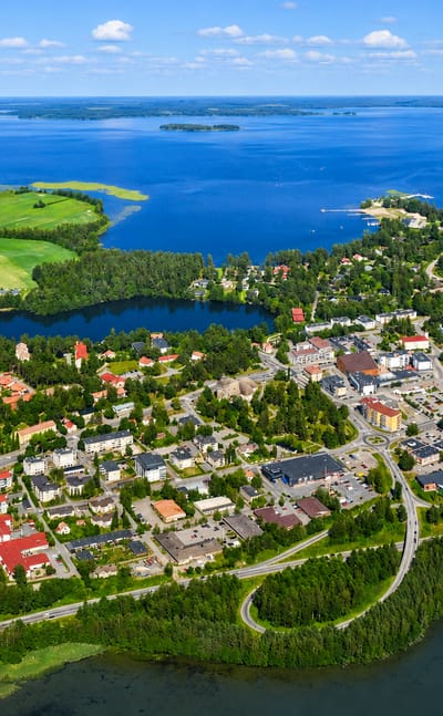 Aerial view of Kangasala town center in Finland, low-rise buildings and a church ringed by forests and blue lakes
