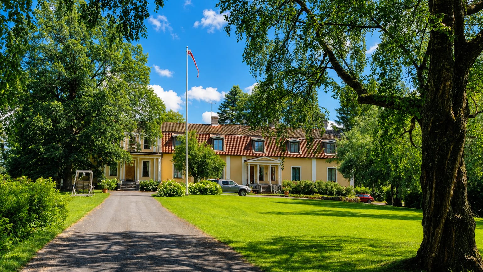 Yellow manor house with a flagpole and gravel drive amid lawns and trees at Kylmäkoski, Finland.