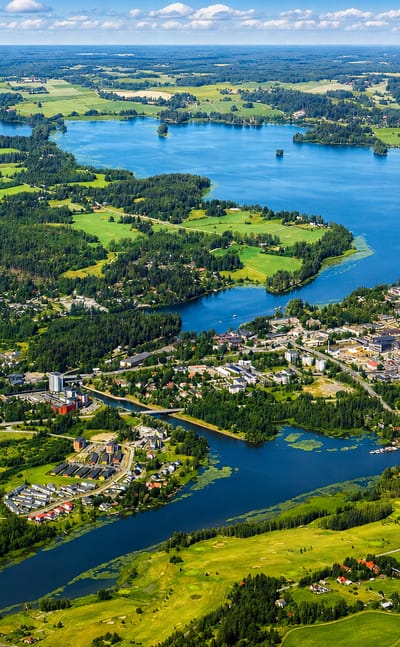 Aerial view of Lempäälä, Finland, a lakeside town set among forested islands and connecting waterways under a bright summer sky