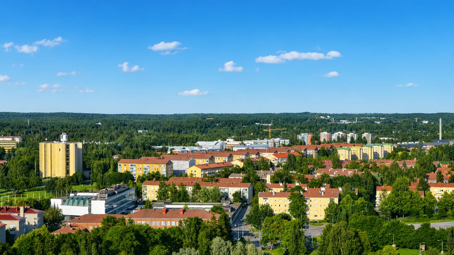 Ochre 1950s apartment blocks with red roofs among birch trees in the Kaleva district of Tampere.