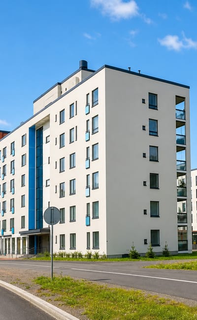 Modern white apartment blocks along a quiet street in Lentavanniemi, a western suburb of Tampere