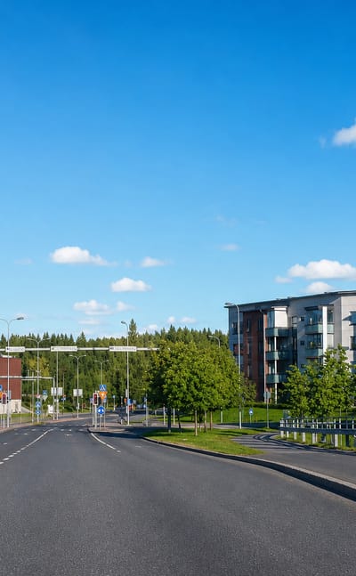 Wide road past a brick shopping centre and modern apartment blocks in Linnainmaa, Tampere.