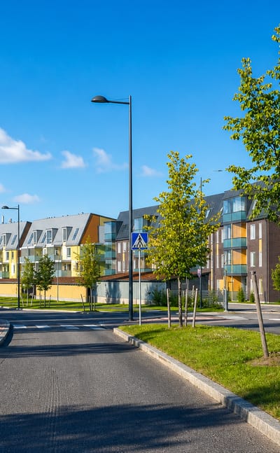 Modern apartment blocks and new streets in Vuores, Tampere, with birch saplings and pedestrian crossings.