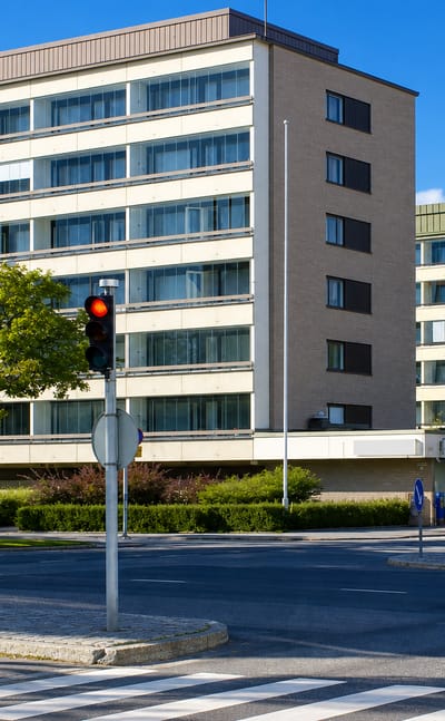 Mid-century apartment blocks at a signalled crossroads with crosswalks in VII kaupunginosa, Vaasa.