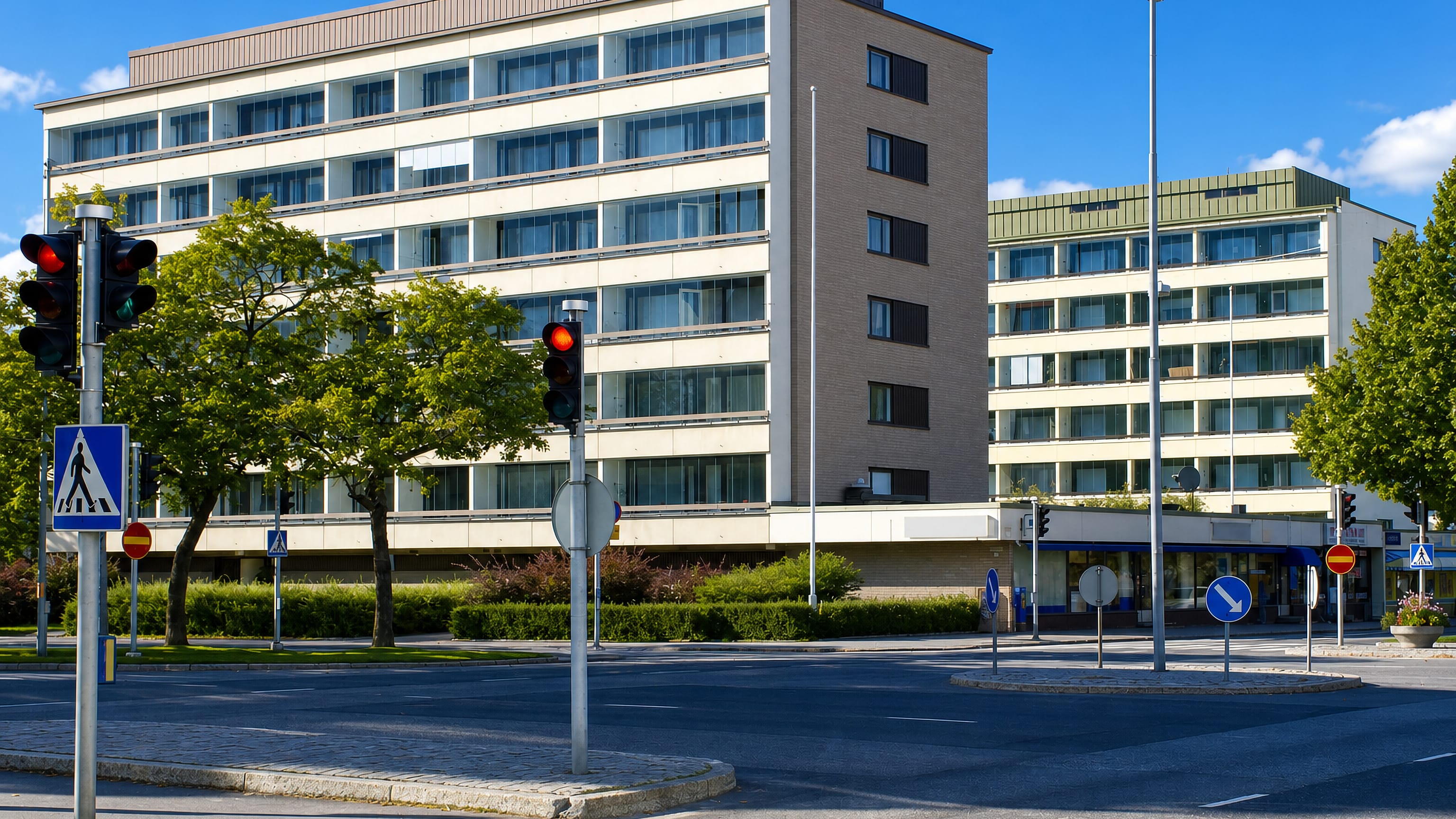 Mid-century apartment blocks at a signalled crossroads with crosswalks in VII kaupunginosa, Vaasa.