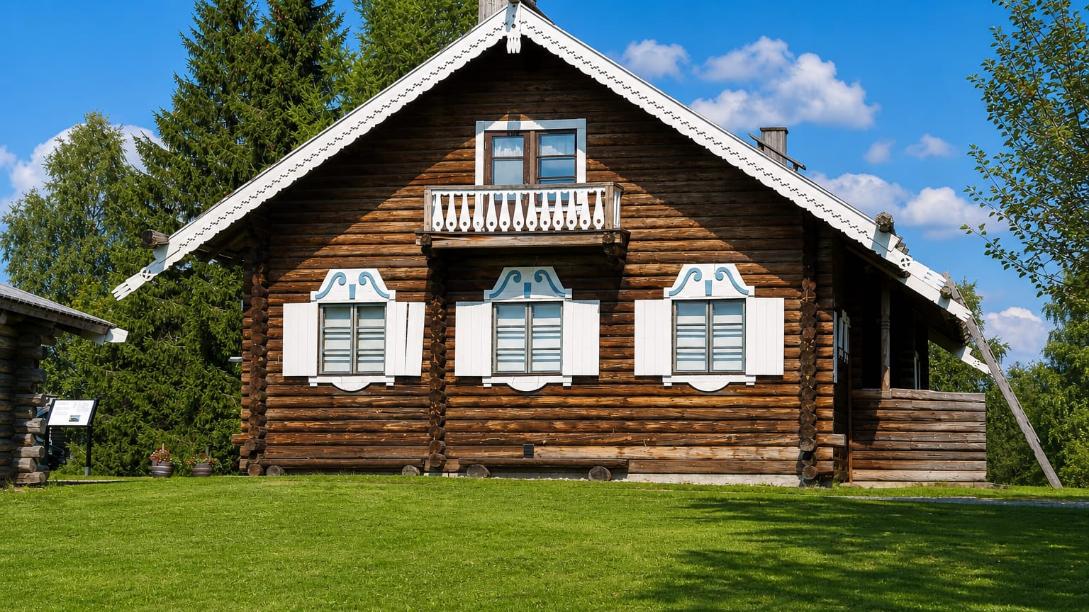A traditional Karelian log house with carved white shutters and a balcony in Ilomantsi, Finland.