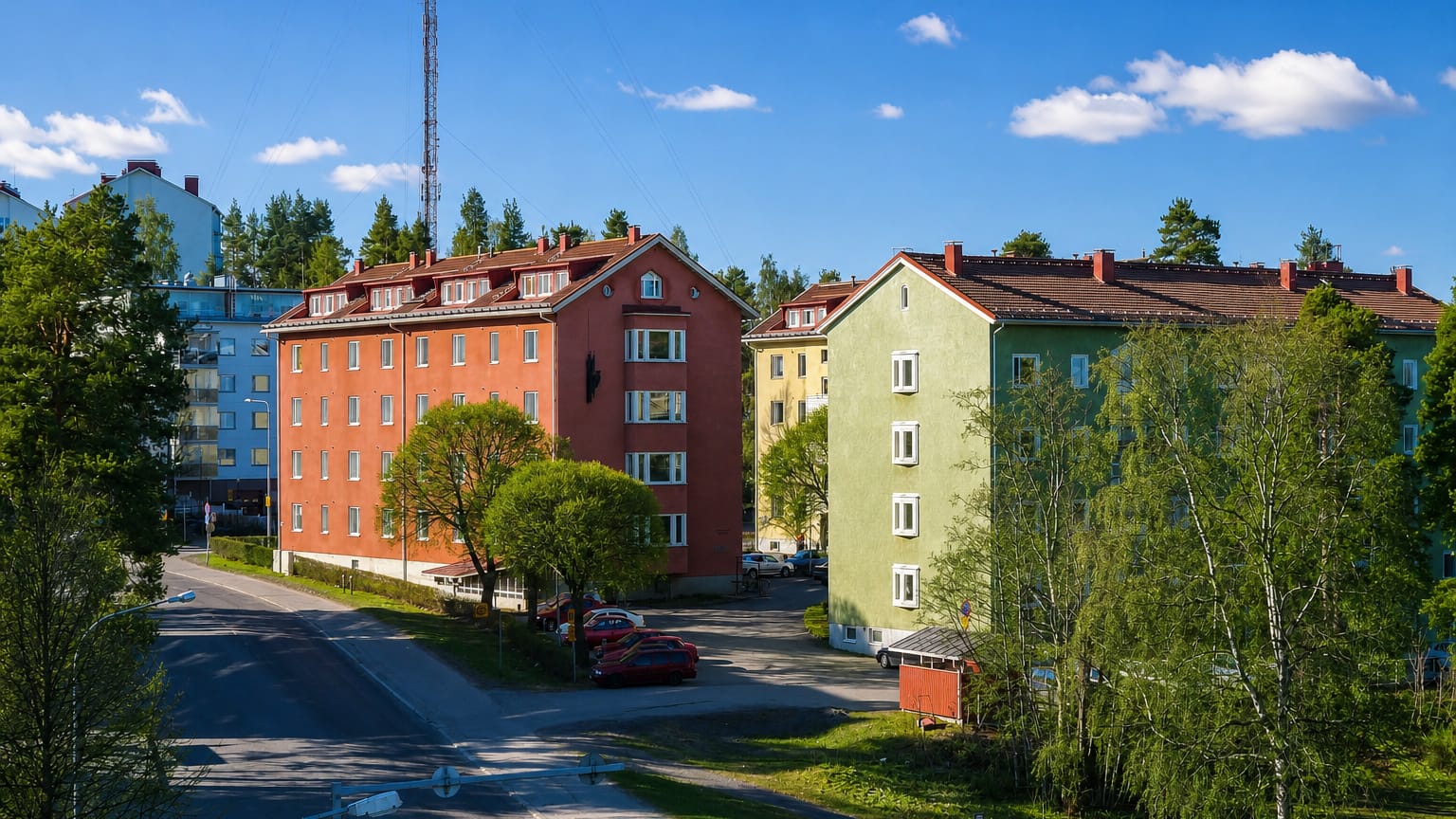 Colorful functionalist apartment blocks along a quiet birch-lined residential street in Niinivaara, Joensuu, Finland