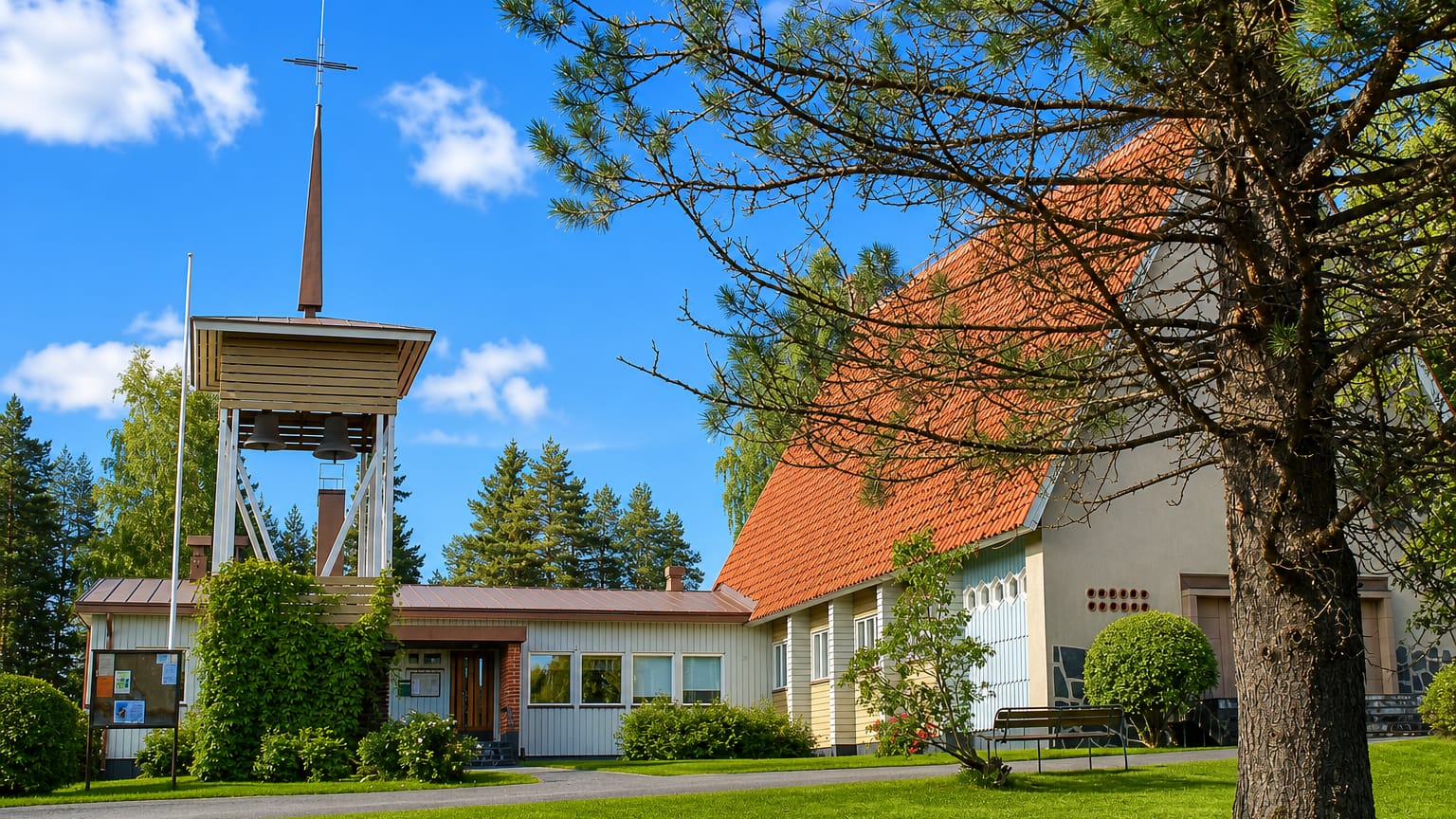 Liperi's modern church with a tall freestanding bell tower and orange-tiled roof on a summer day.