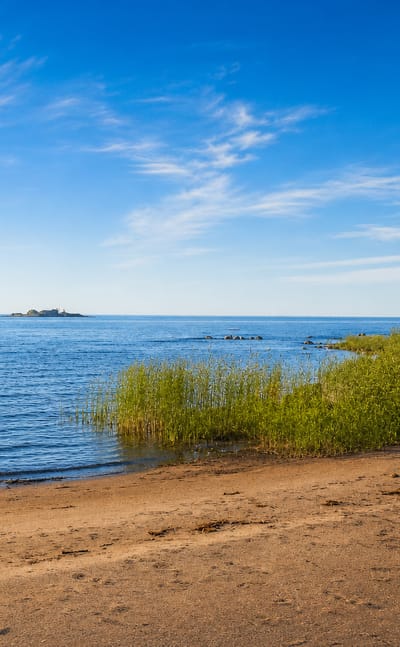 Wide sandy beach at Kalajoki, Finland, meeting the calm blue Gulf of Bothnia under a bright summer sky