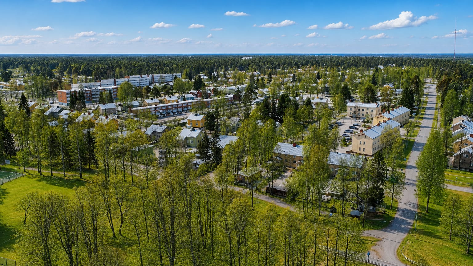 Aerial view of wooden houses, apartment blocks and birch trees in Nokela, a residential district of Oulu.