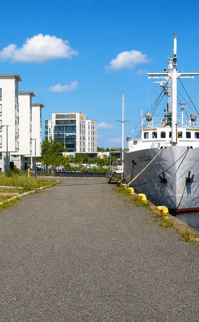 The vessel Oulu moored at the quay below new white apartment blocks in Toppilansaari, Oulu.
