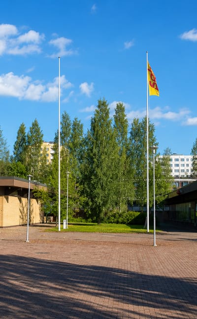 Brick-paved square, flagpoles and apartment blocks at the Särkiniemi neighbourhood centre in Kuopio.