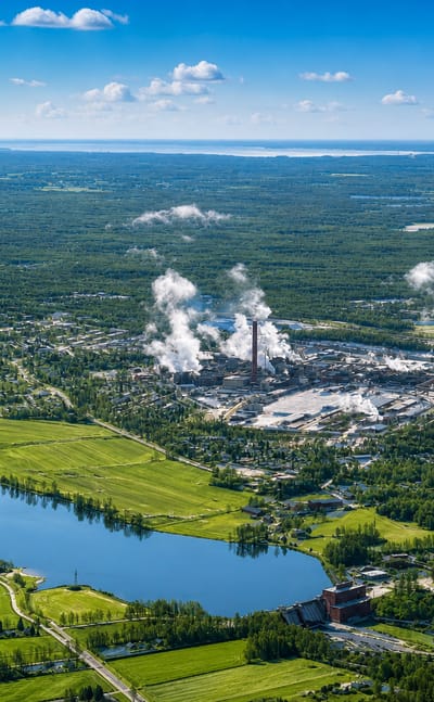 Aerial view of Harjavalta, Finland, its riverside industrial smelting park amid green forests and fields by the Kokemäki River