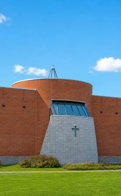 Modern red-brick church with a tall bell tower and open lawns in Sammonlahti, Lappeenranta.