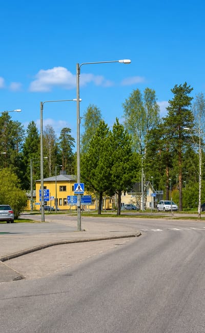 A quiet town street with an ABC service station and a church tower in Isojoki, Finland.