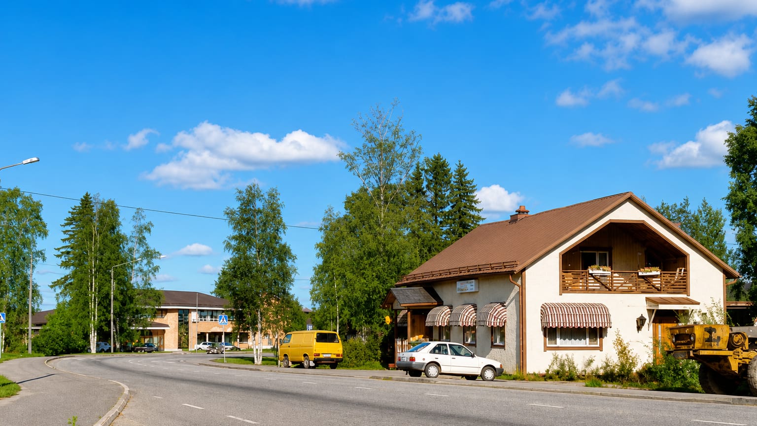 Roadside house with striped awnings, parked cars and birch trees along a curving road in Karijoki, Finland.