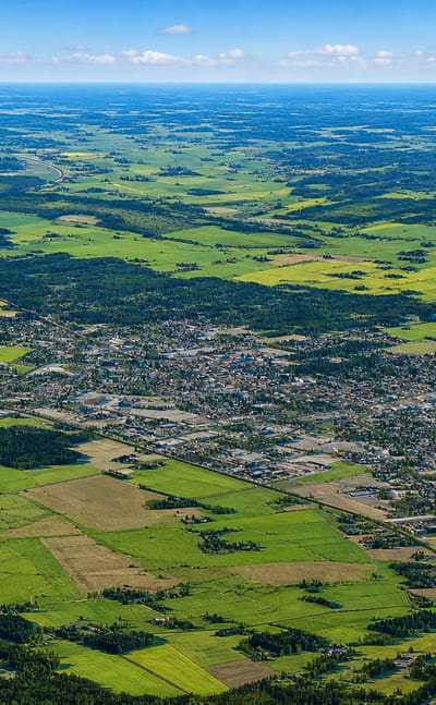Aerial view of Kauhajoki, Finland, a small town amid flat green and yellow farmland in South Ostrobothnia.