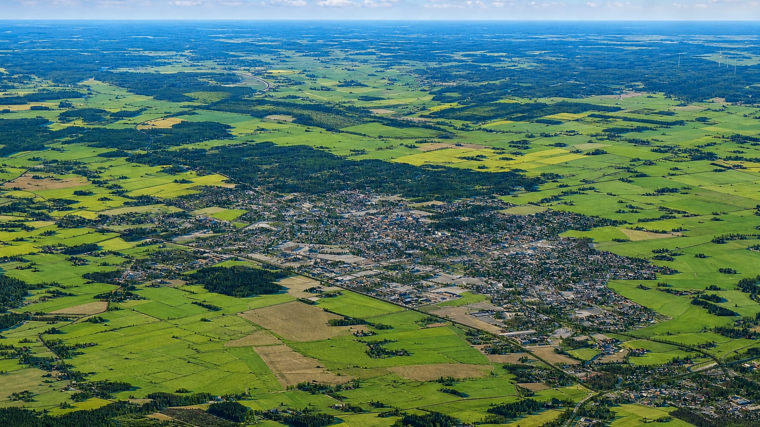 Aerial view of Kauhajoki, Finland, a small town amid flat green and yellow farmland in South Ostrobothnia.