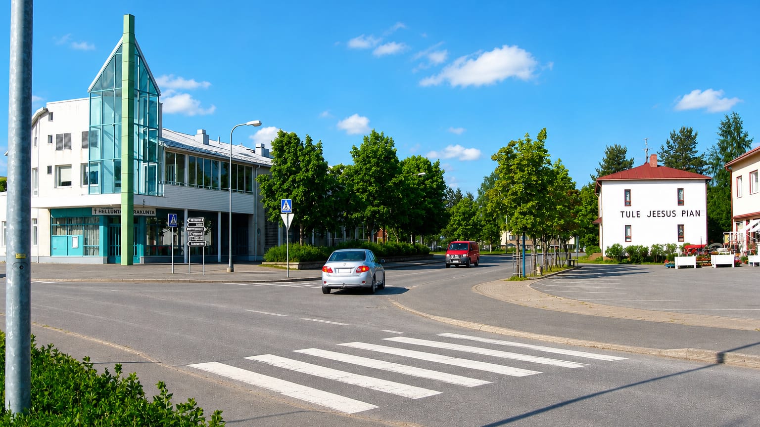 Street corner in Lappajärvi, Finland with a modern glass-fronted building and a marked pedestrian crossing.