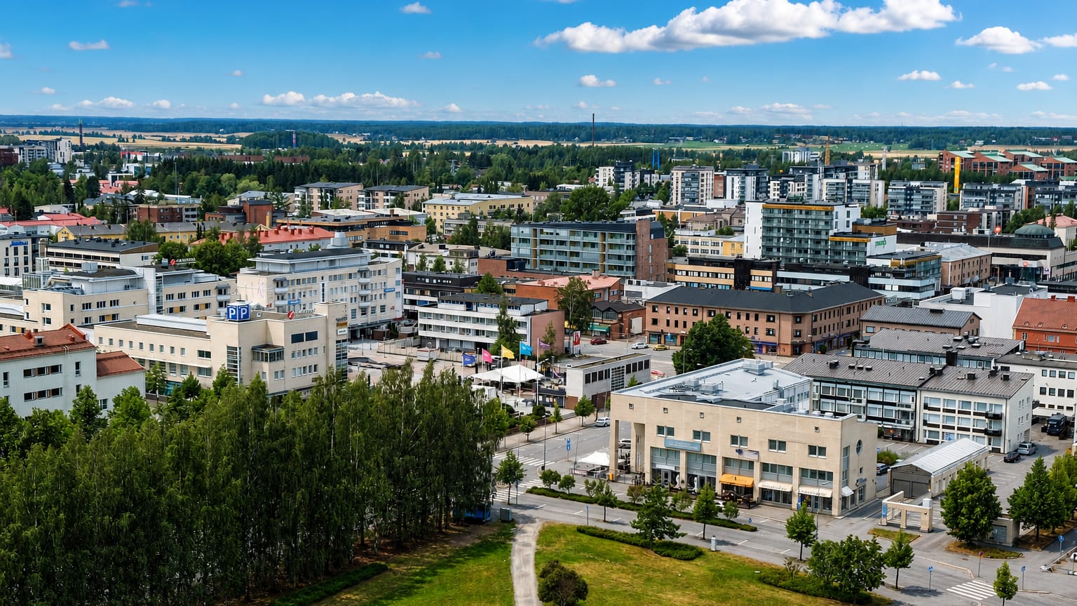 Elevated daytime view over central Seinäjoki, Finland, with mid-rise buildings and flat forested plains reaching the horizon.