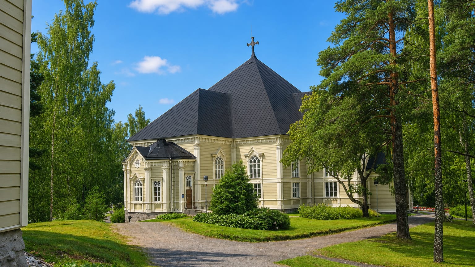 Kangasniemi's yellow wooden church with a dark octagonal roof and cross, framed by birches and a gravel path.