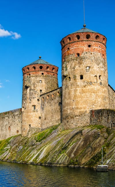 Olavinlinna, the medieval three-towered stone castle on a rocky islet surrounded by lake water at Savonlinna, Finland.