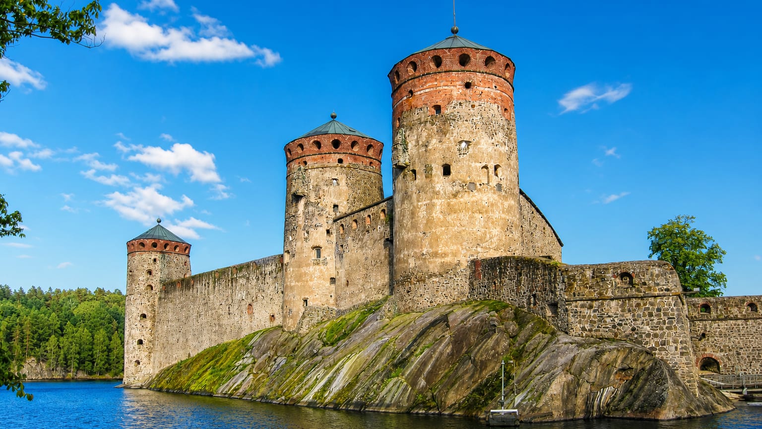 Olavinlinna, the medieval three-towered stone castle on a rocky islet surrounded by lake water at Savonlinna, Finland.