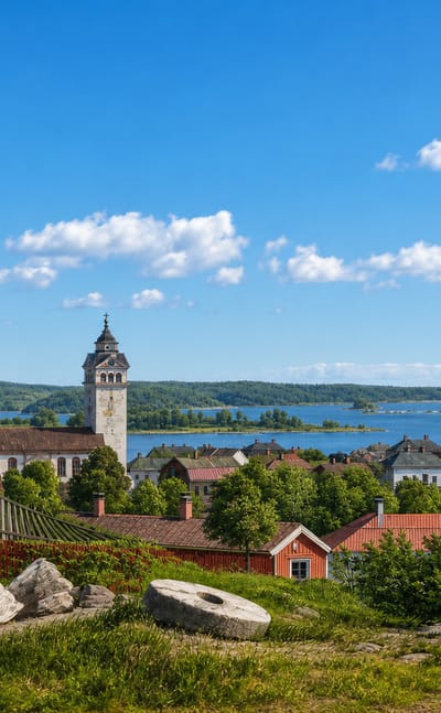 Ekenäs old town with its church spire rising above red-roofed wooden houses, the sea and archipelago beyond
