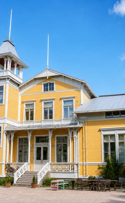 Yellow timber manor house with a white cupola tower and gravel forecourt at Espoonkartano, Espoo