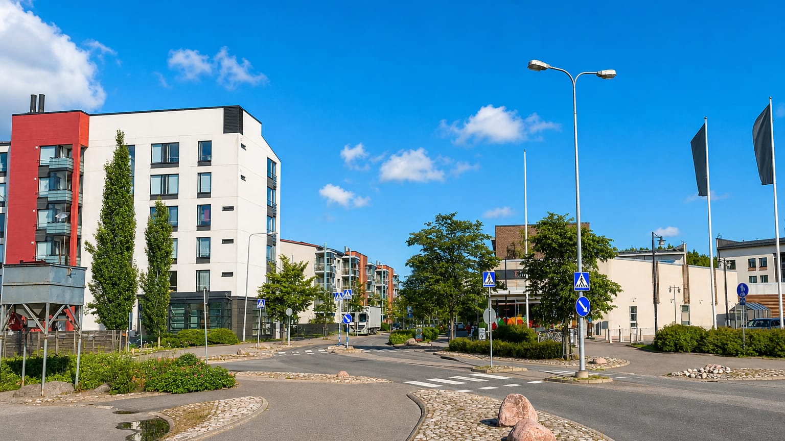 Modern apartment blocks and a landscaped road junction in the Kilo neighbourhood of Espoo.