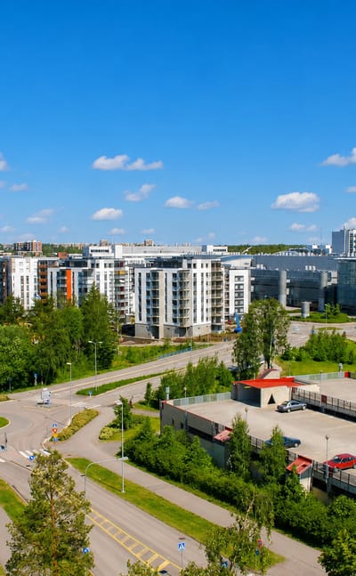 Aerial daytime view of Matinkylä, Espoo, with modern white apartment blocks set among forest and suburban roads